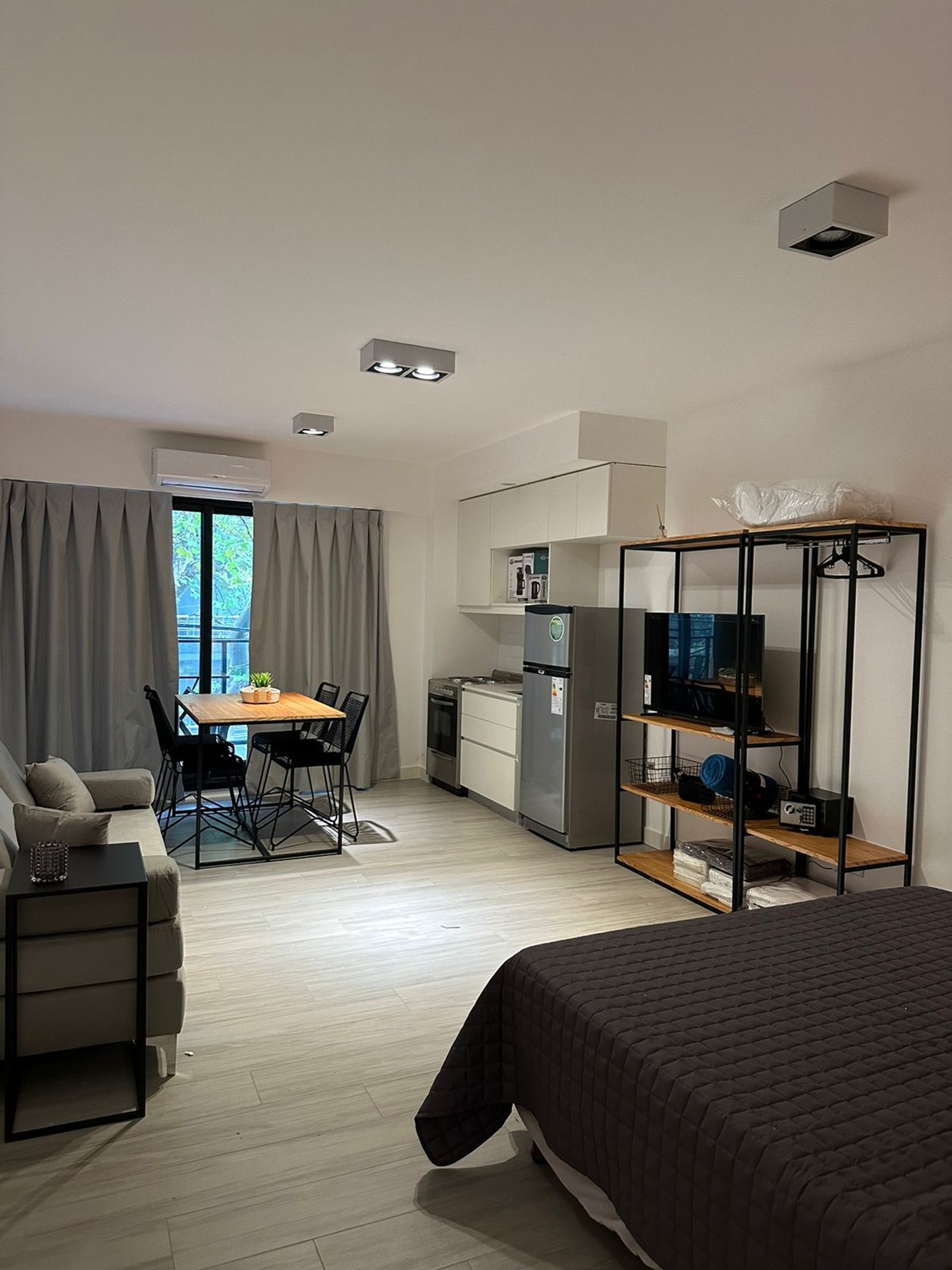 Monoambiente moderno con sala, cocina integrada y cama — proyecto Airbnb, por Estudio Hirsch, en Buenos Aires
